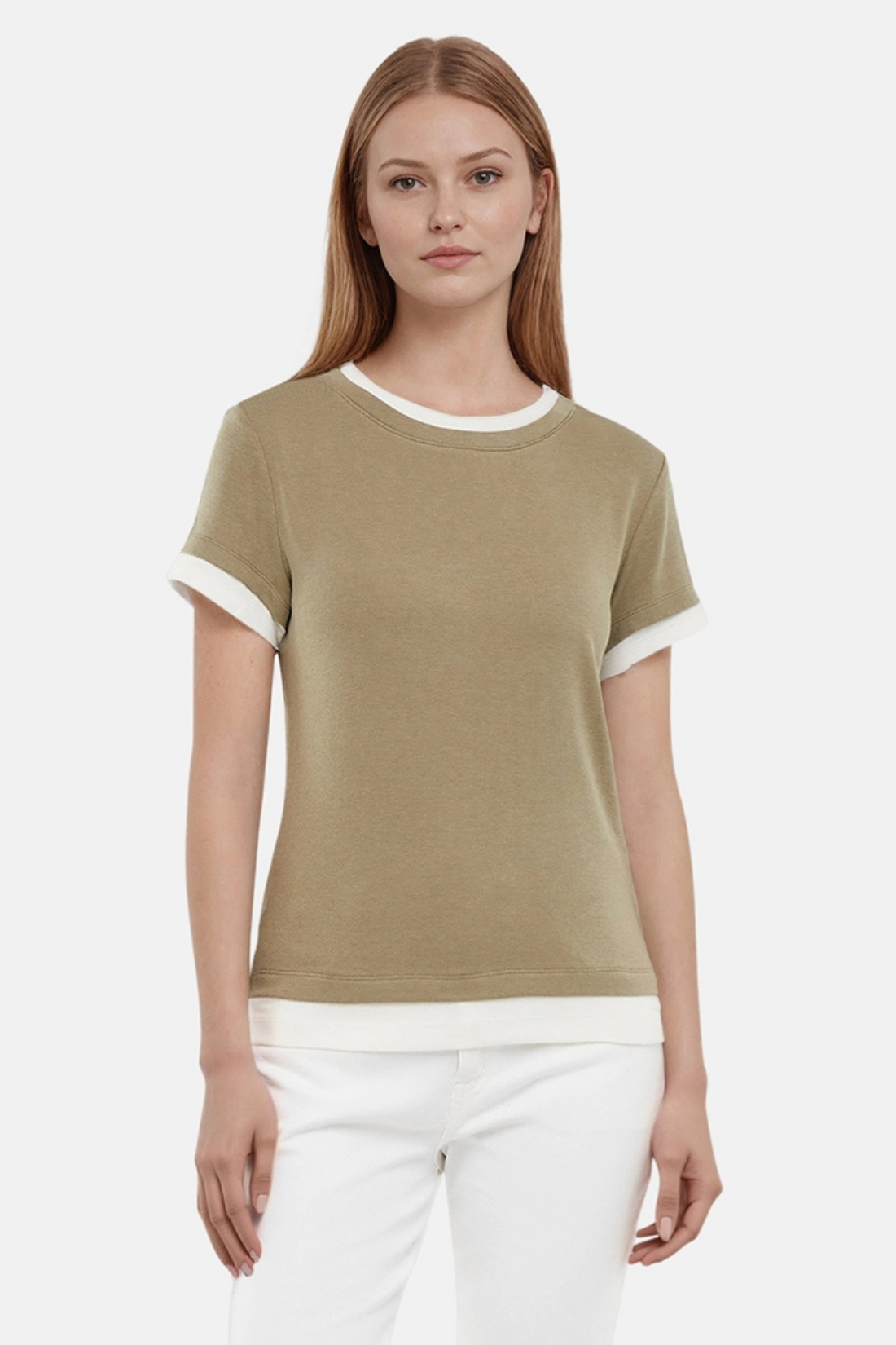 Front of woman wearing a green tee with white layered hem and white pants on a light gray background