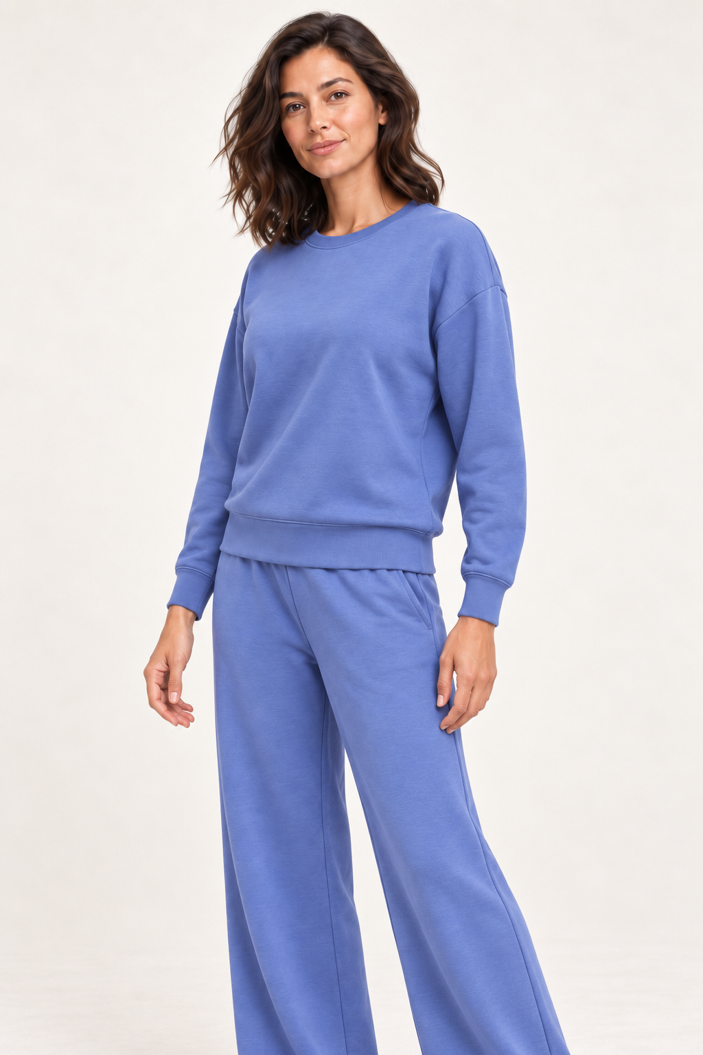 Woman wearing the blue Lana Pullover and matching pants, three-quarter studio view