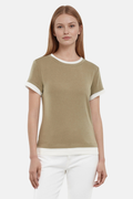 Front of woman wearing a green tee with white layered hem and white pants on a light gray background #color_deep-lichen-green
