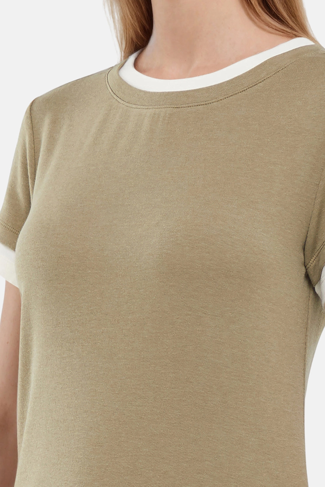 Close-up of a woman wearing a green t-shirt with a white layered neckline. 