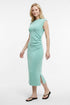 Woman wearing a light green dress with a slit on a white background. 