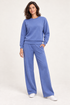 Woman wearing the blue Lana Pullover and matching wide-leg pants, front studio view