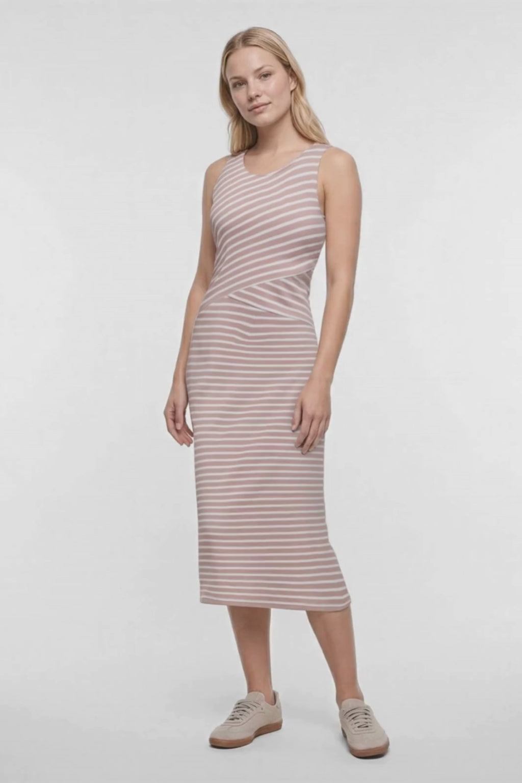 Video of a woman modeling a sleeveless midi dress with horizontal light brown and white stripes, paired with beige sneakers, against a plain white studio background. #color_stucco-amy-stripe