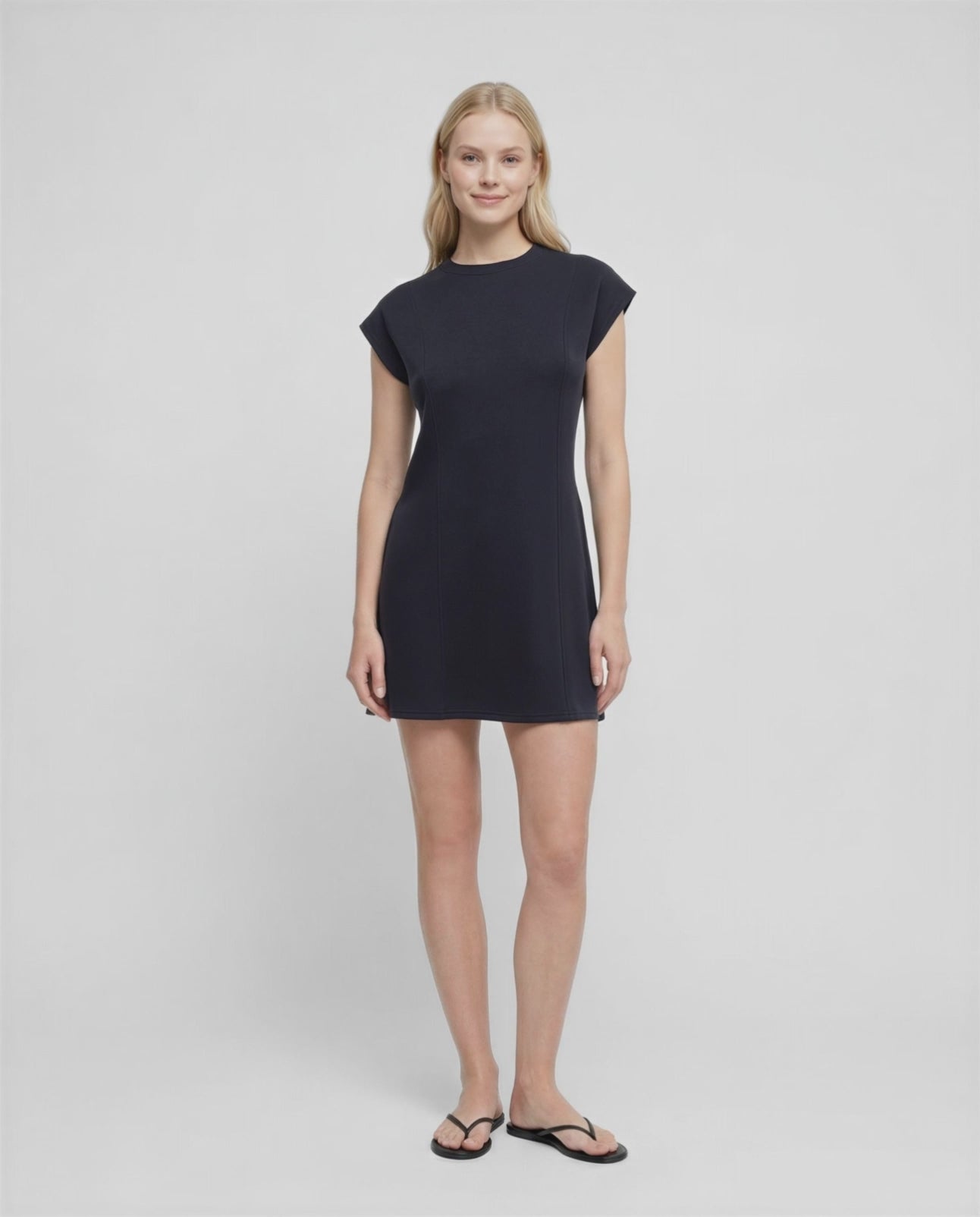 Video view of woman wearing a black mini dress on a white background.
